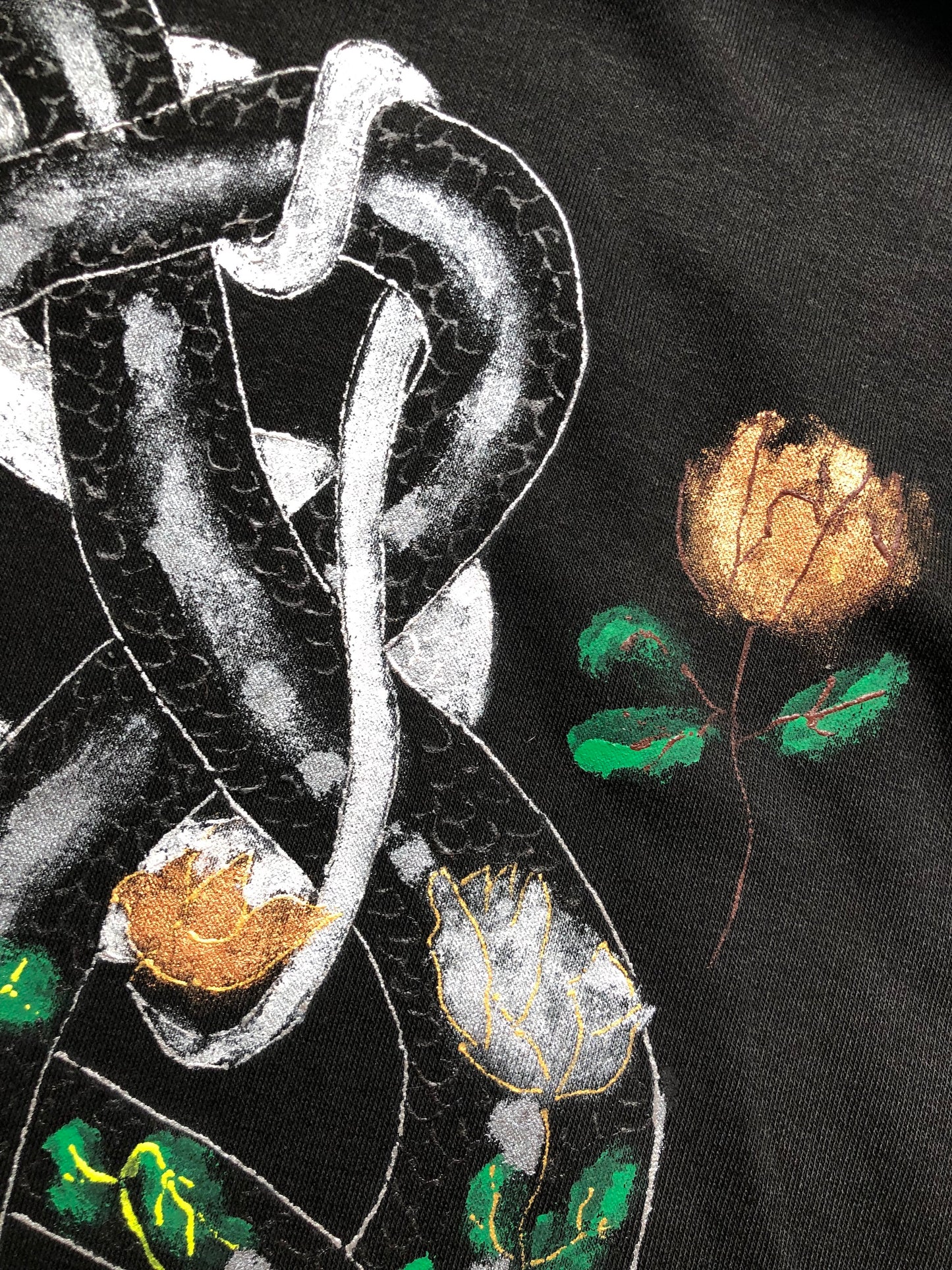 Women's snake hoodie details of patterns of snakes and flowers in golden hues