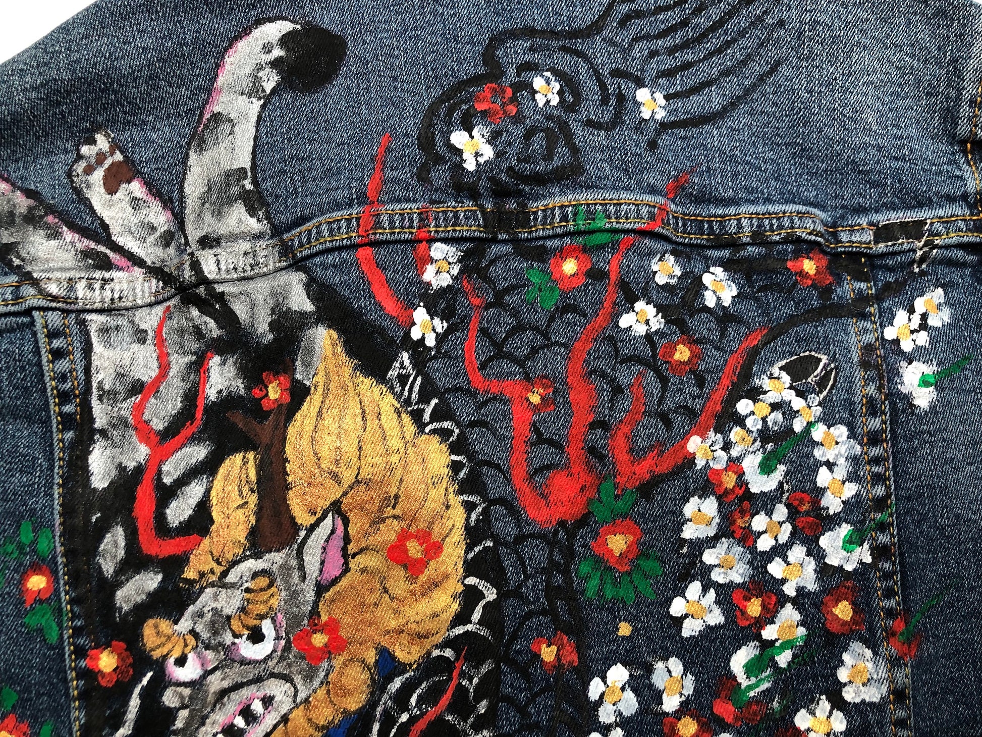 The tail of a cat and a demon on a women's denim jacket reverse side