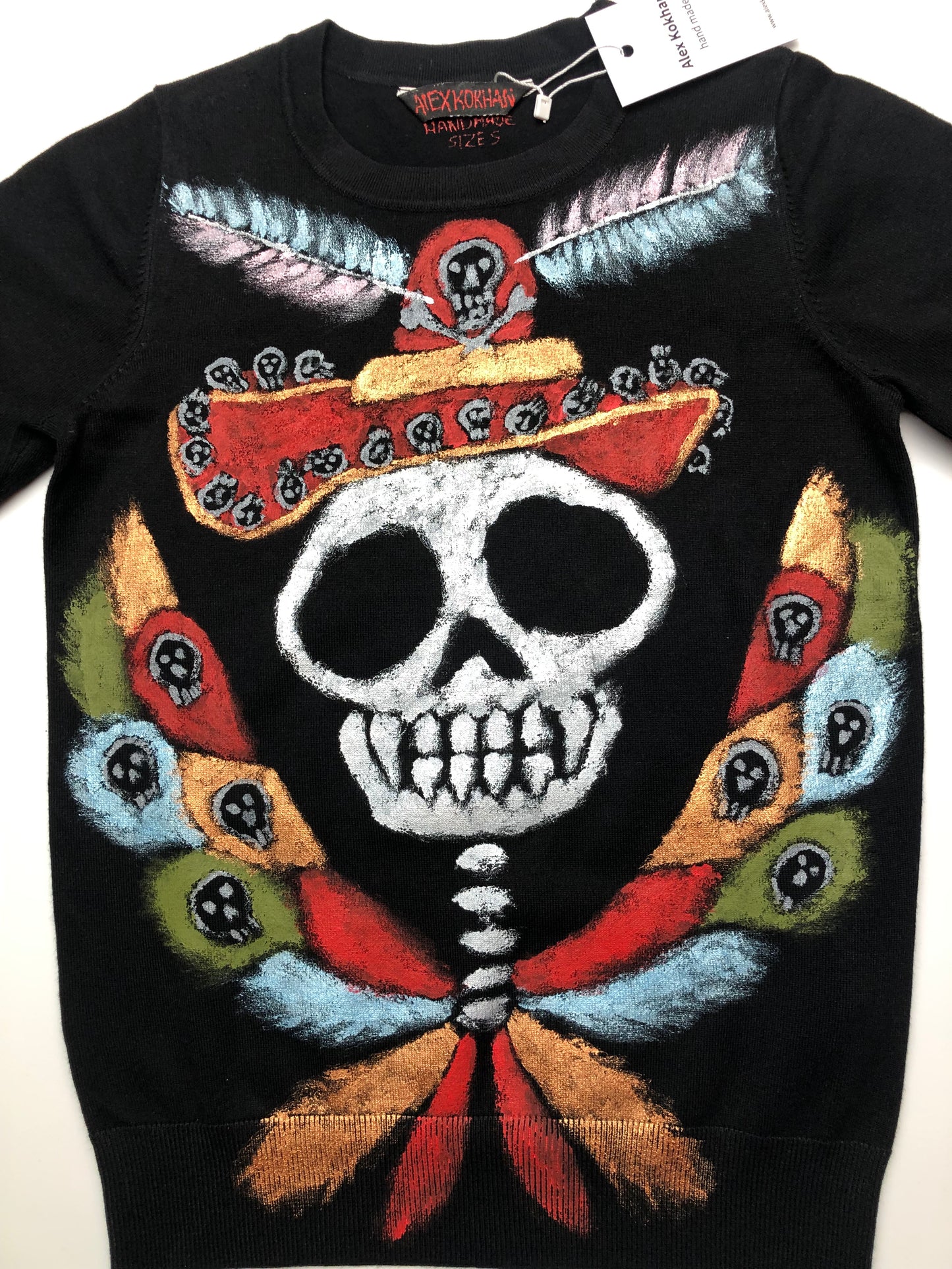 Acrylic painting on women's clothing with many colors. Women's blouse Winged skull in a hat