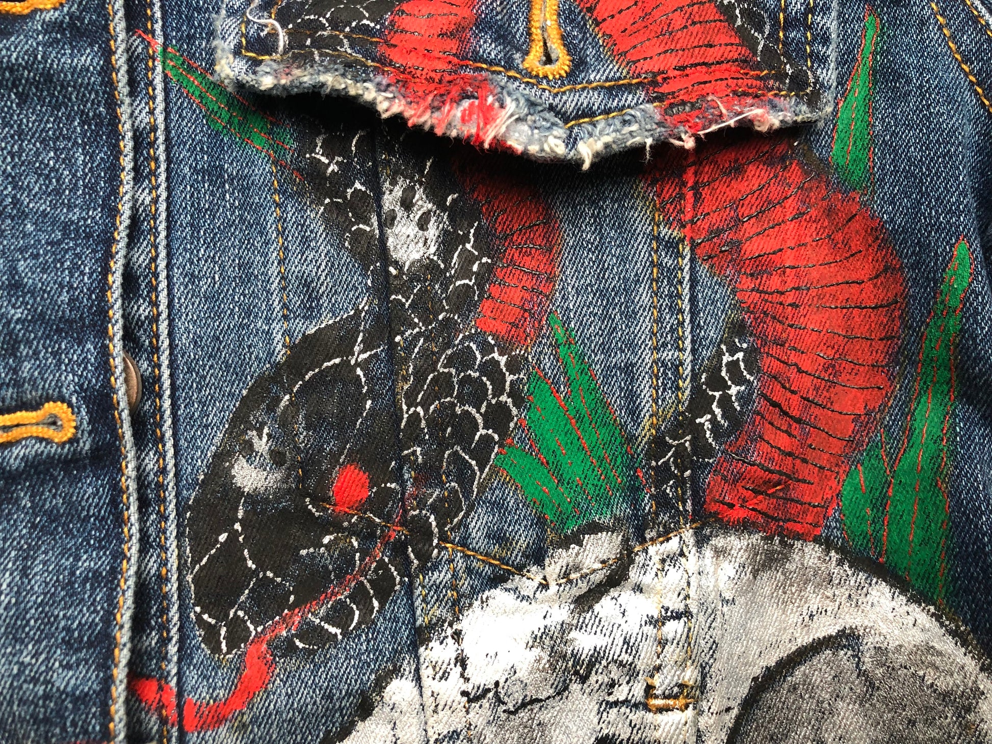 Very detailed painting of a snake on a women's denim jacket