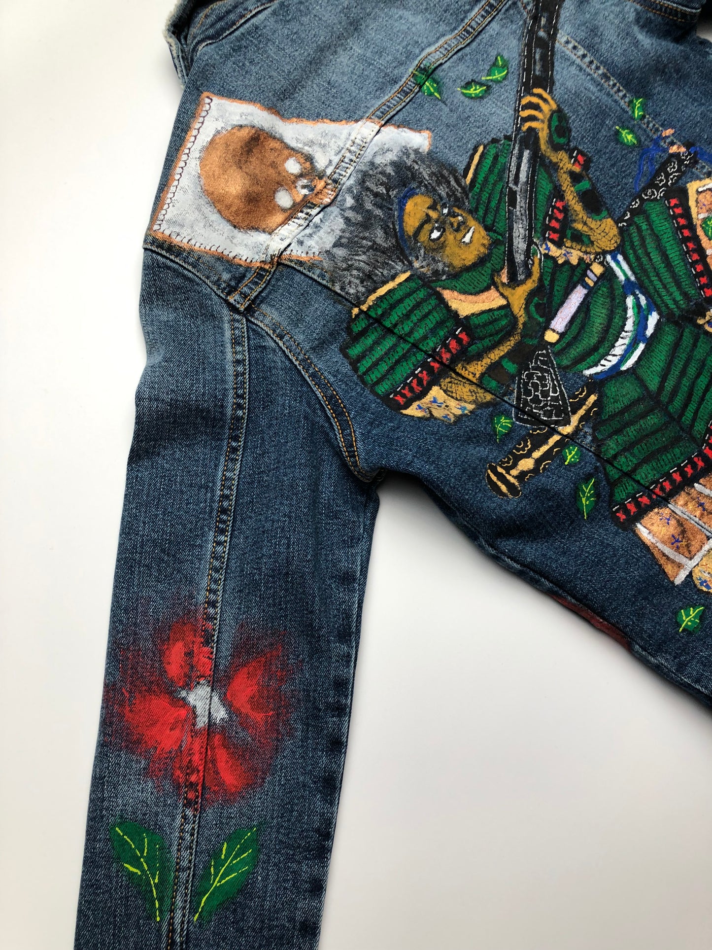 Details on the back of the Japanese warrior denim jacket and flower patterns on the sleeve