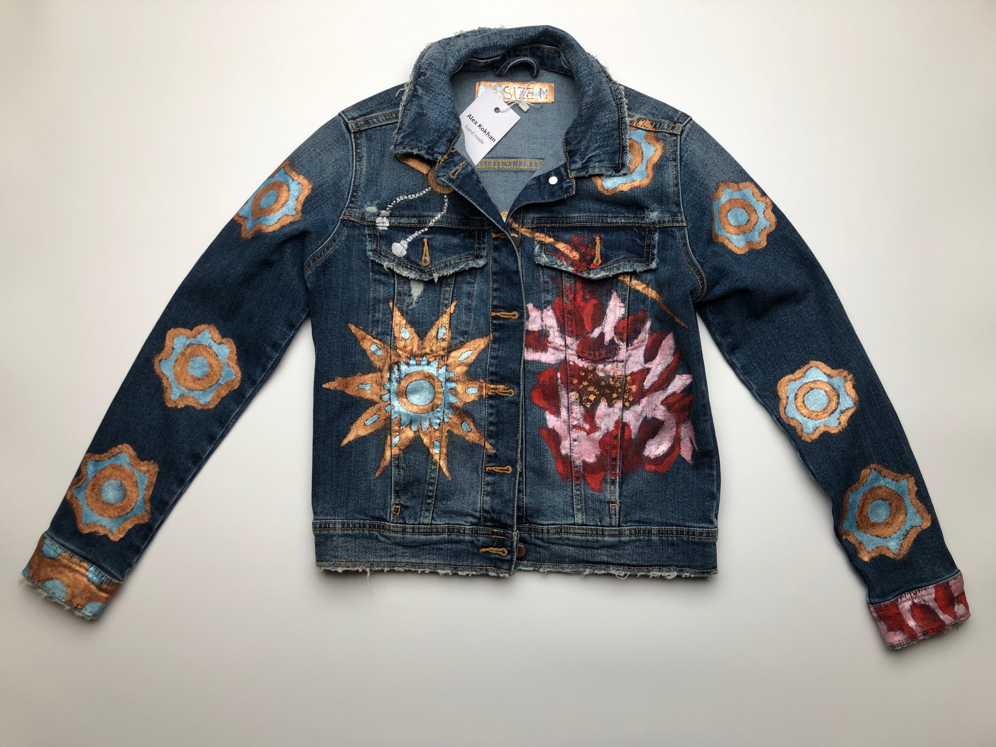 Gold and turquoise patterns on a women's denim jacket