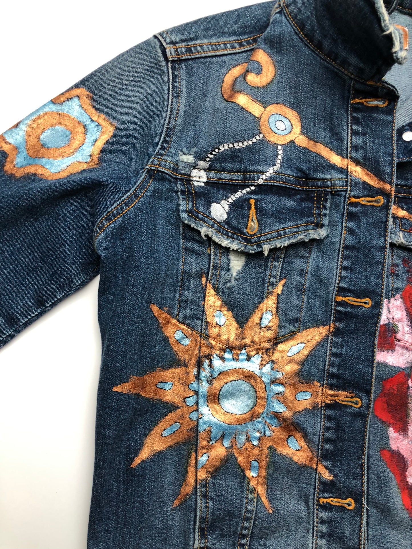 Gold and turquoise star patterns and barrette detail on a women's denim jacket