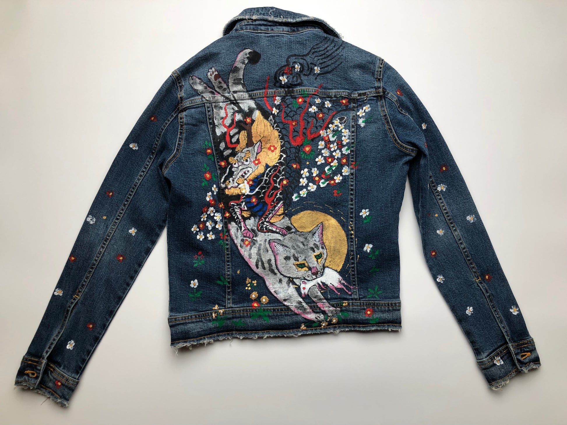 A cat with a mouse and a demon on a women's handmade denim jacket reverse side