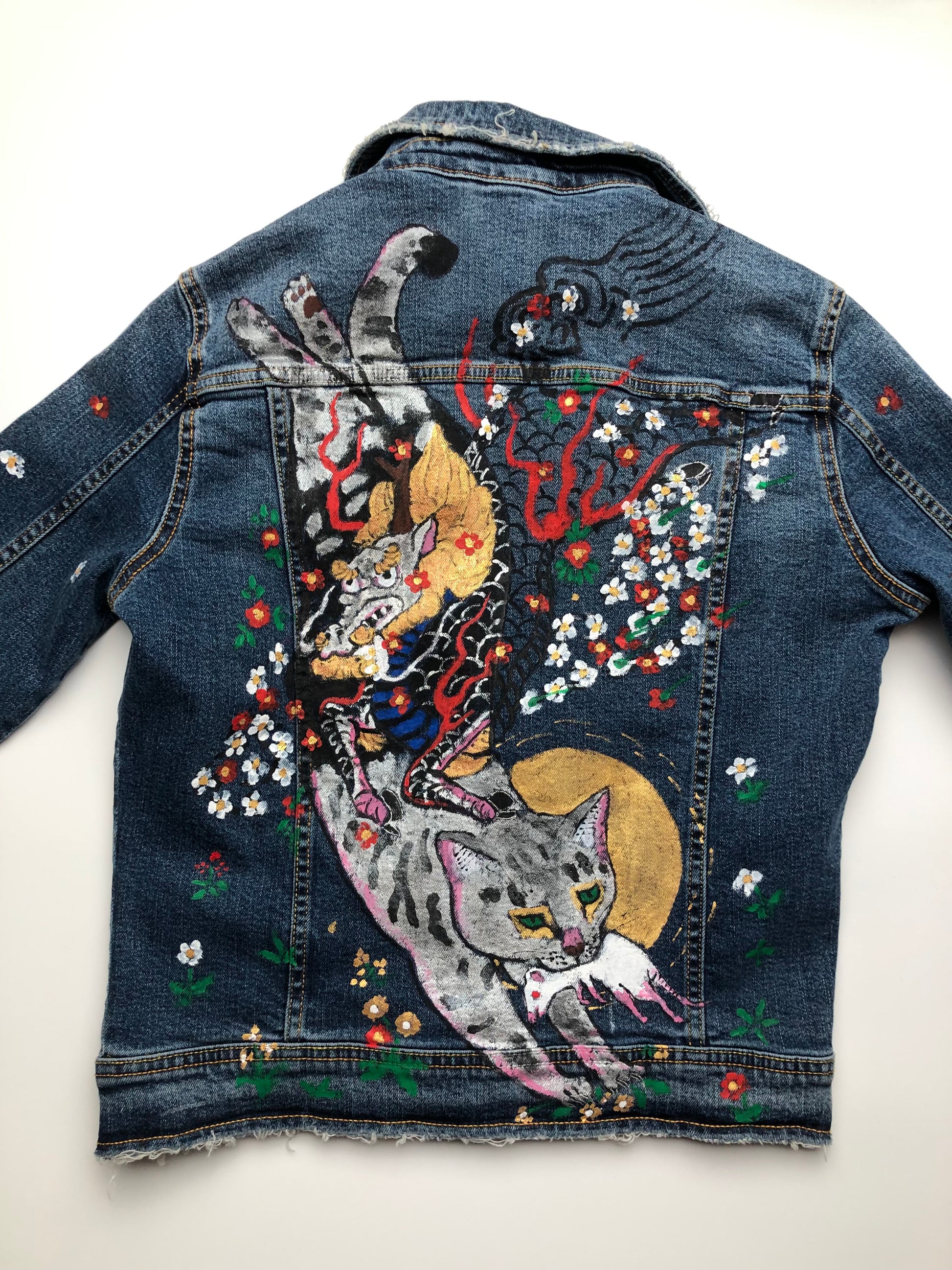 A scary cat with a demon on the back on a women's denim jacket