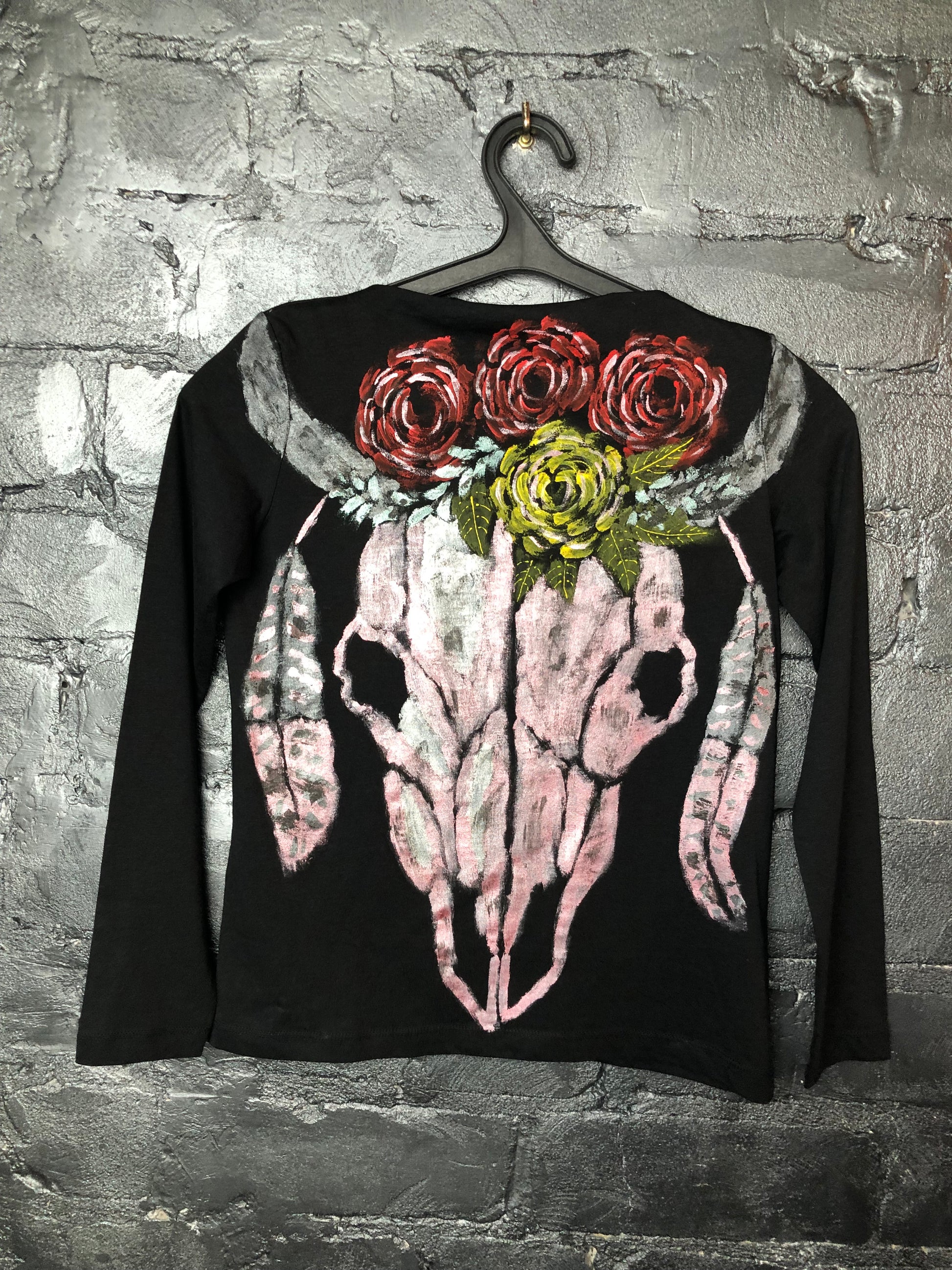 Women's long sleeve black T-shirt with a pattern of a skull, horns, feathers and flowers.