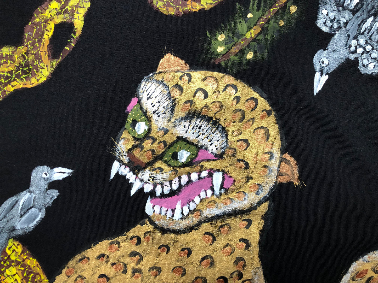 Detailed muzzle of the beast with fangs and green eyes and a bird on women's clothing