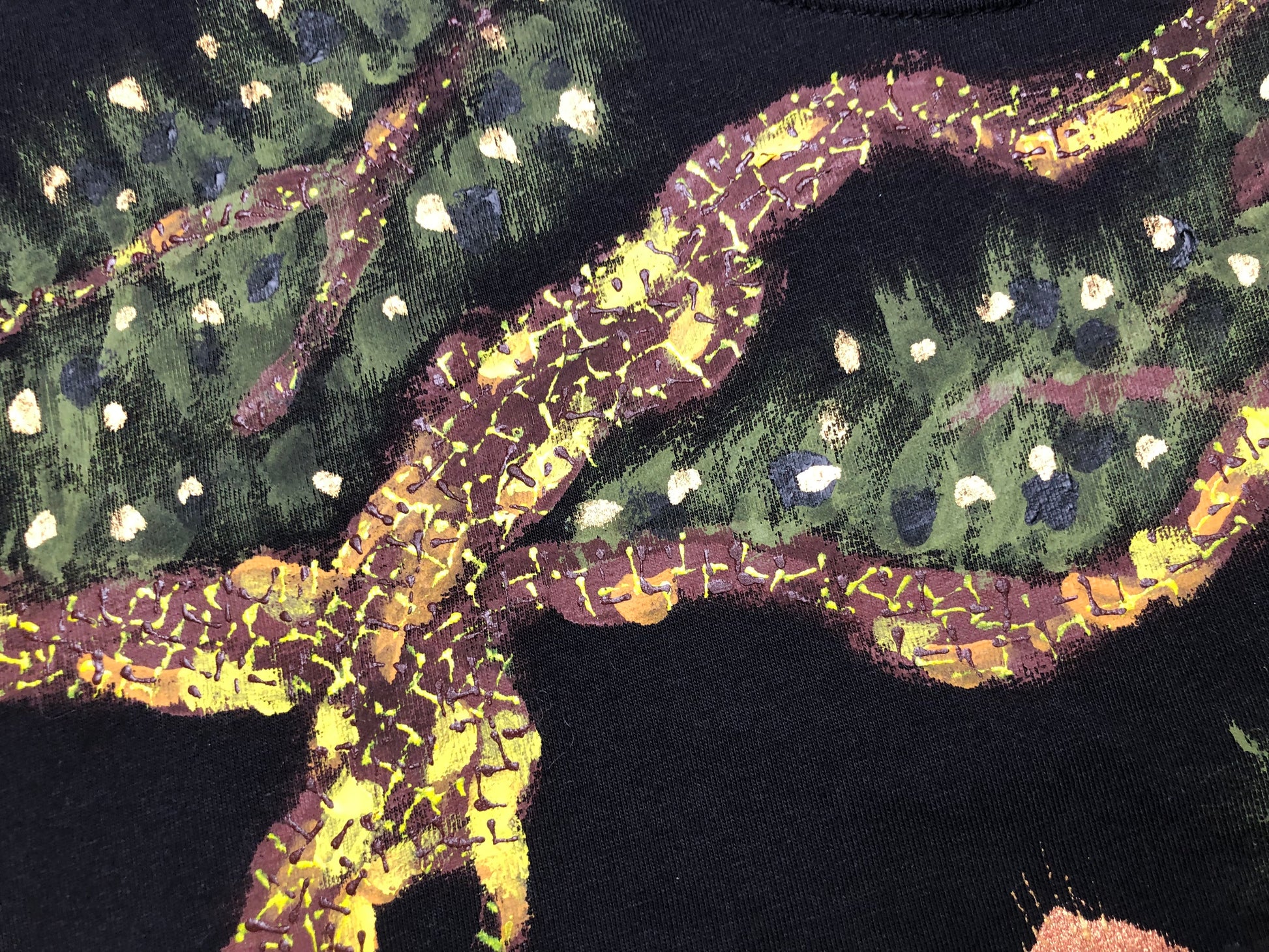 Detail painting of a tree and foliage on a T-shirt