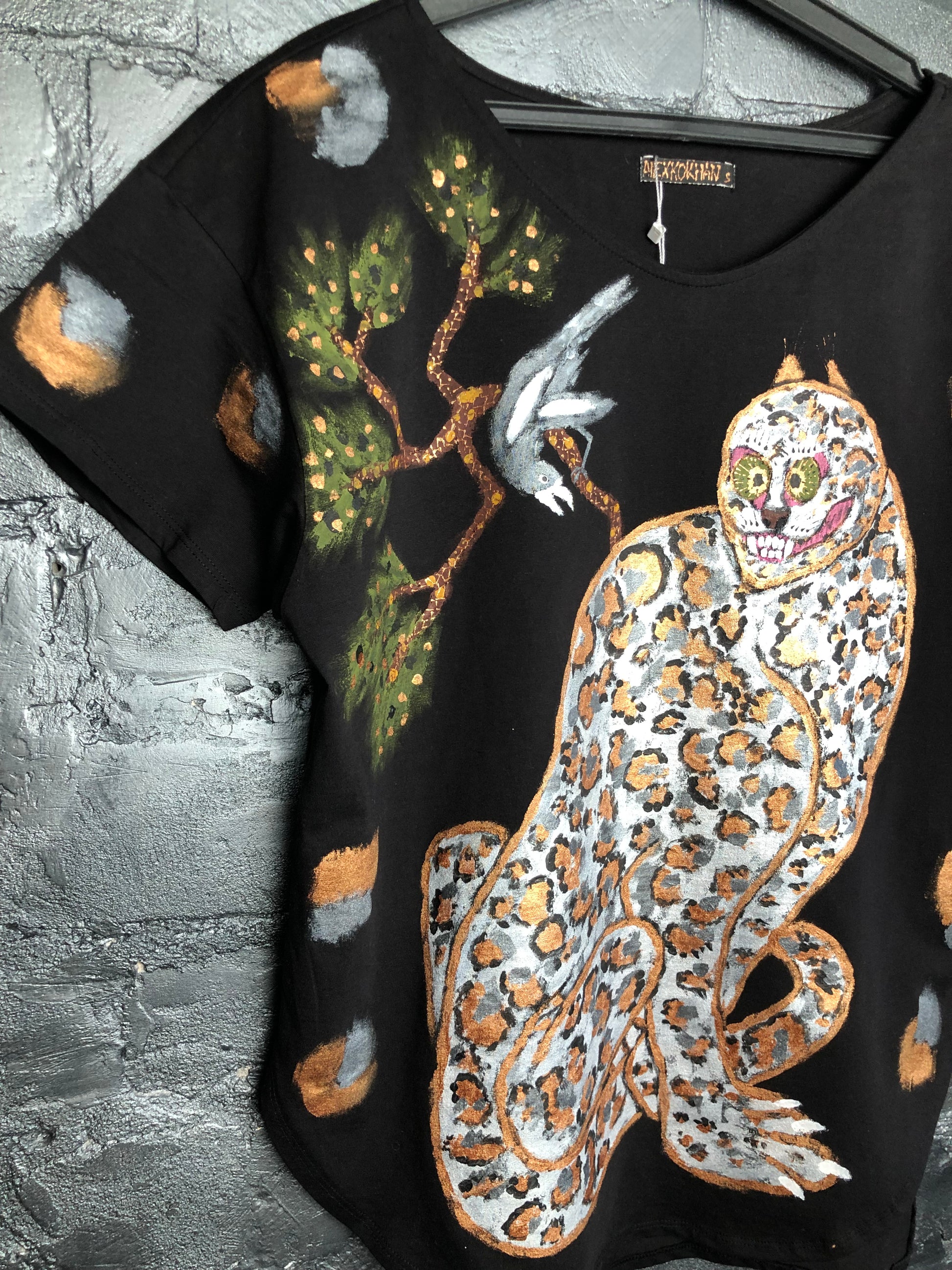 Side view of premium best women's t-shirt with hand painted leopard and bird on branch in interior