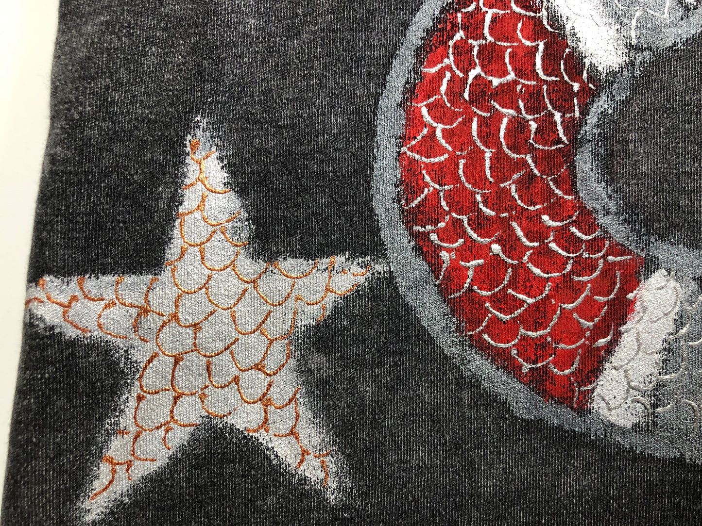 Detailed silver star with bronze scales and red snake on a women's t-shirt