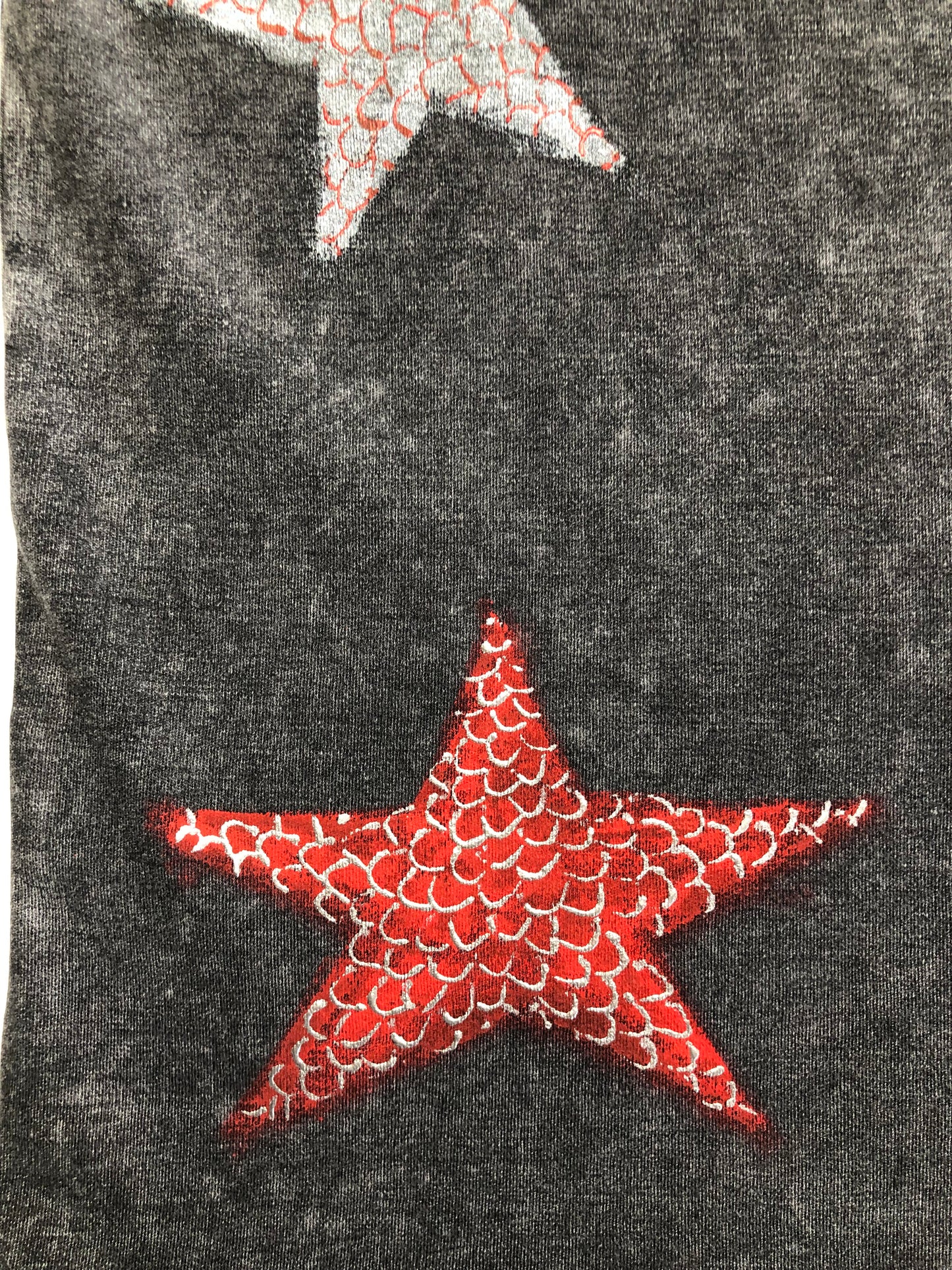 Red star on clothes in detail. Hand painted t-shirt.