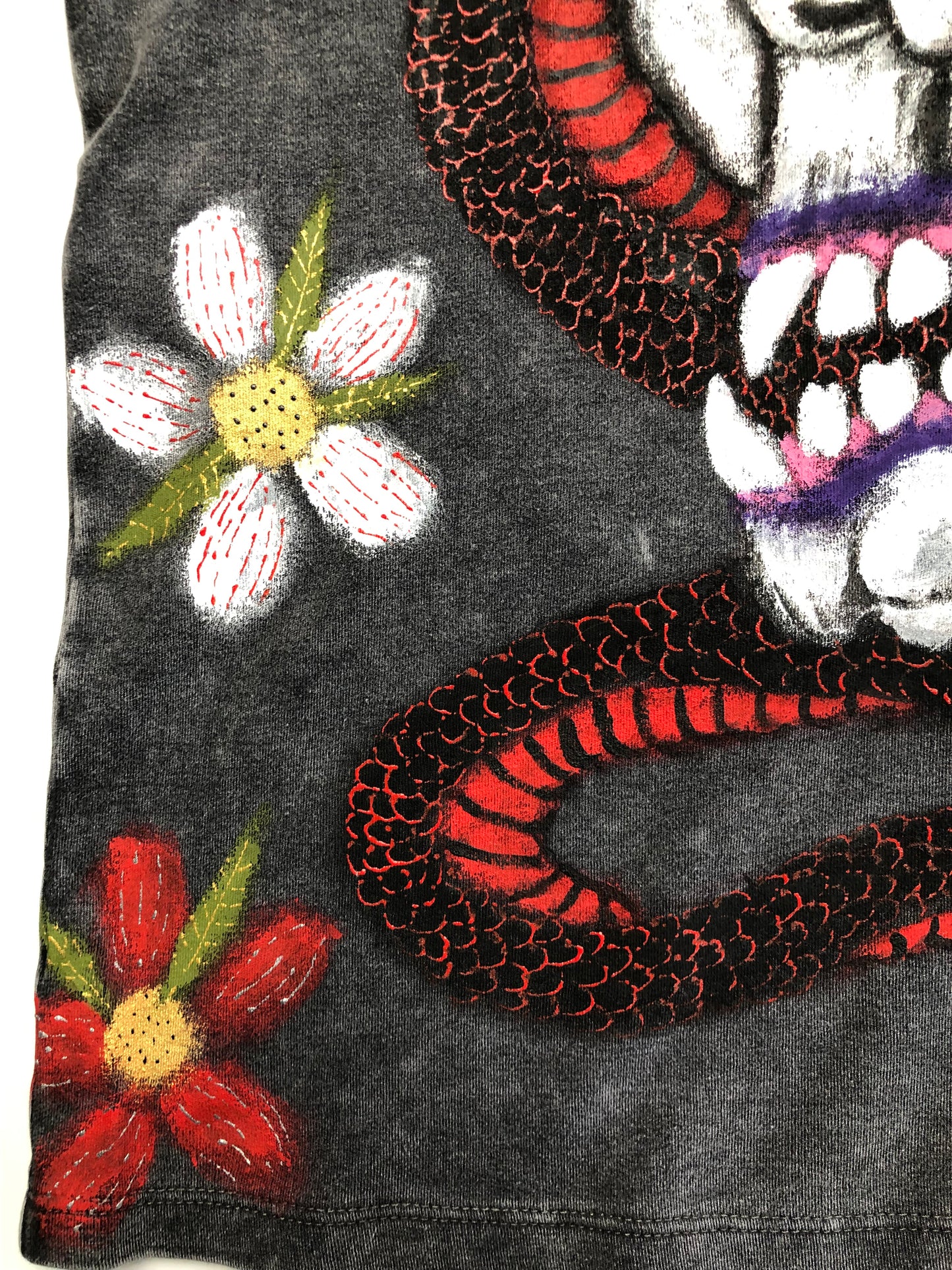 Flower design details on a T -shirt with a snake and a demon