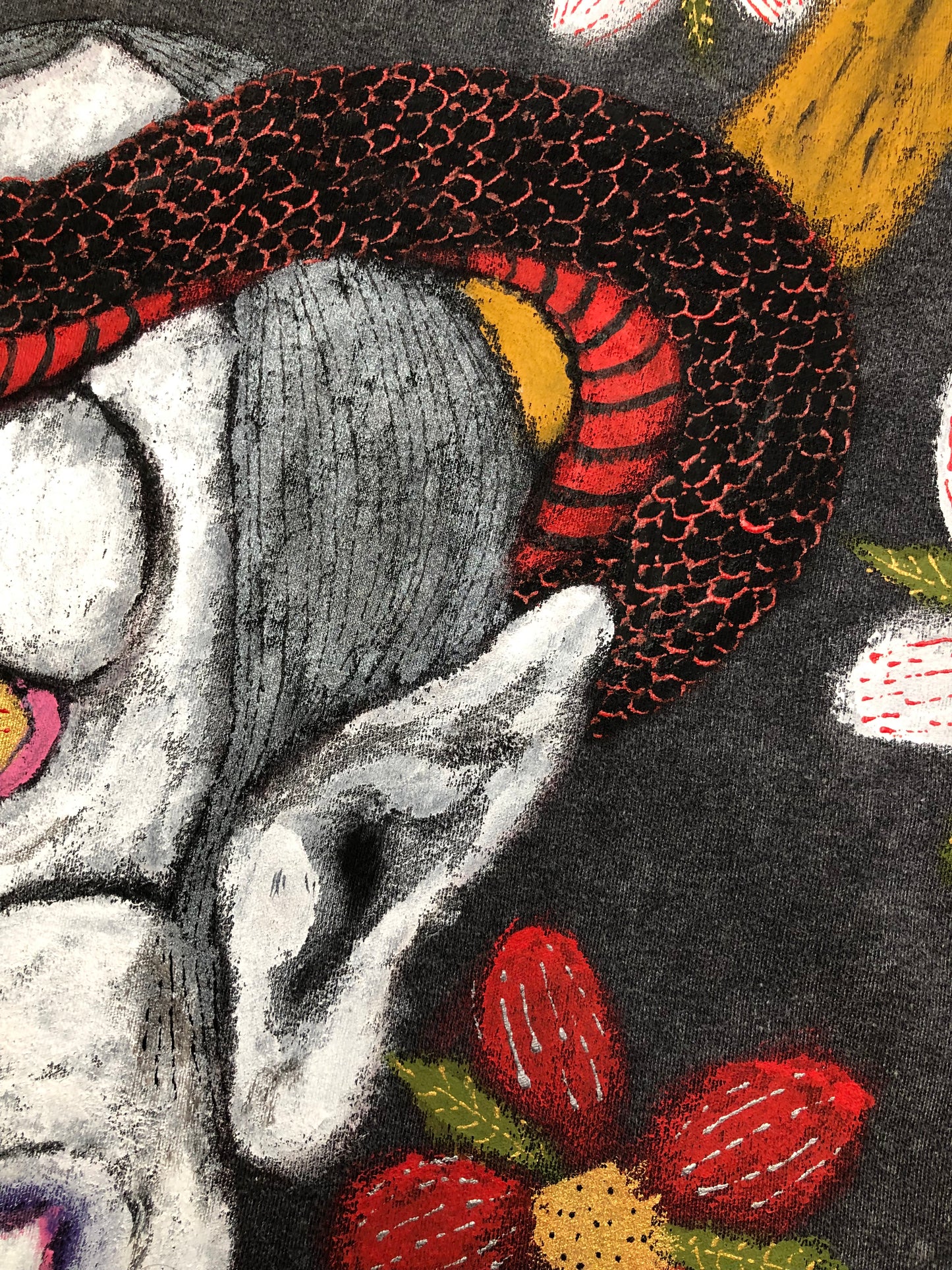 Detail the demon's ear with horns and snakes on a T -shirt
