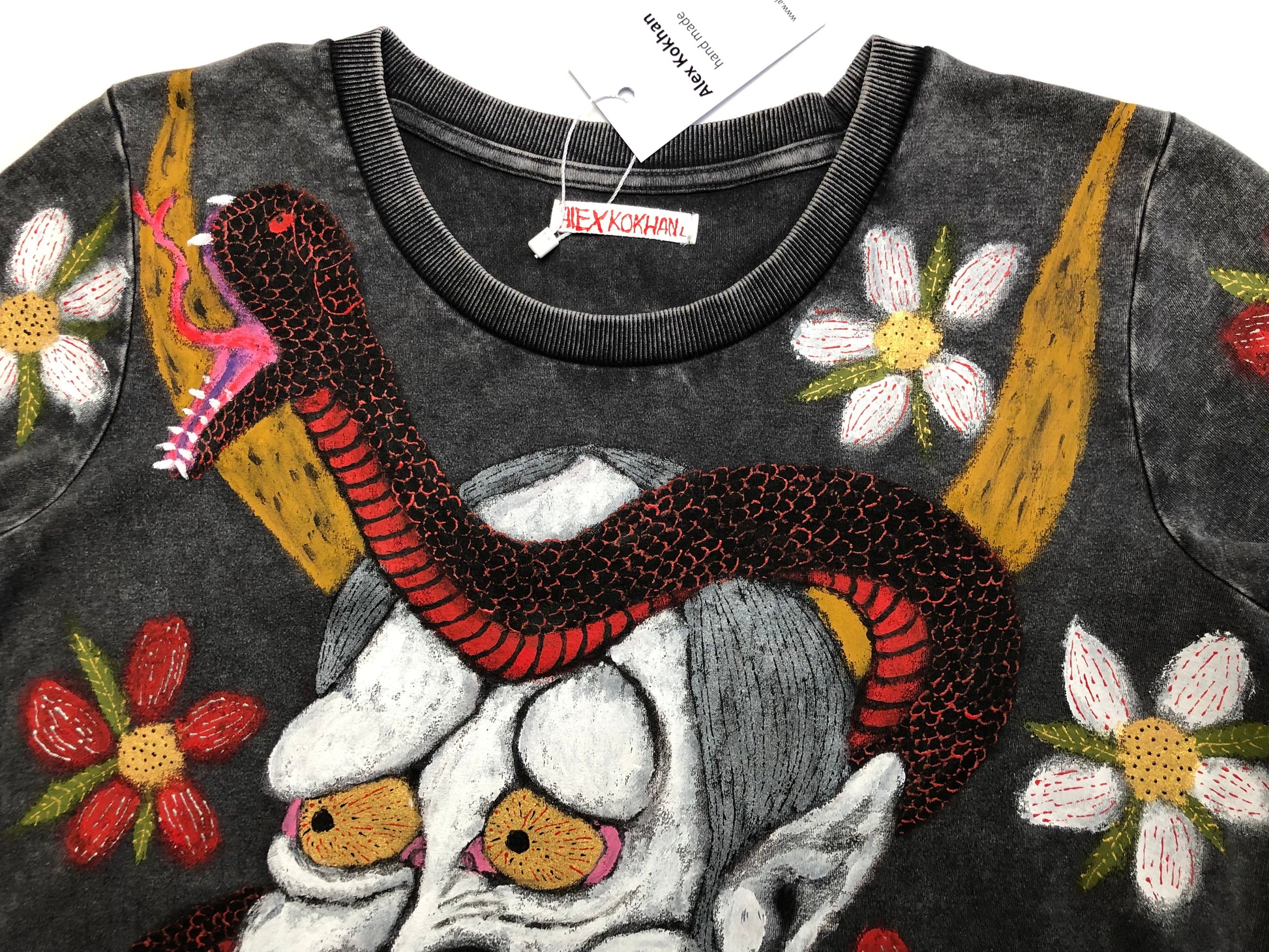 The upper part of the T -shirt with a demon, snake and floral design