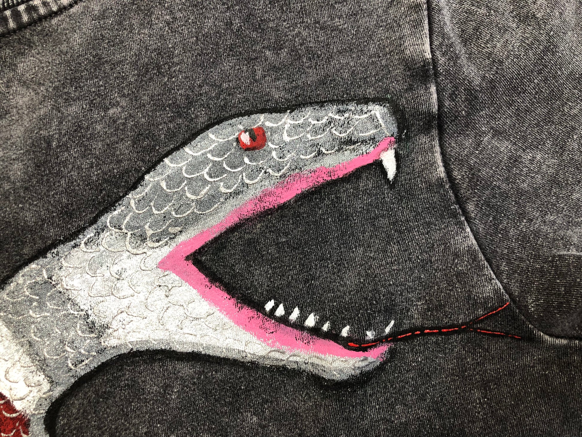 The mouth of a snake with a tongue on women's clothing in detail